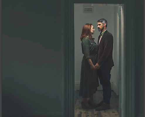 view of actors Rachel and Ben through a doorway into an empty room